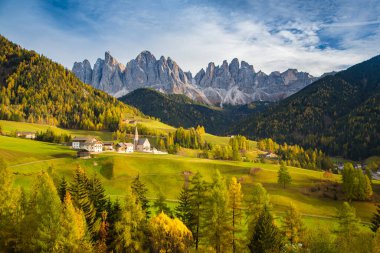 Dolomitlerin güzel manzarası... Santa Maddelana dağ köyü... sonbaharda gün batımında güzel bir altın akşam ışığı... Val di Funes, Güney Tyrol, kuzey İtalya....