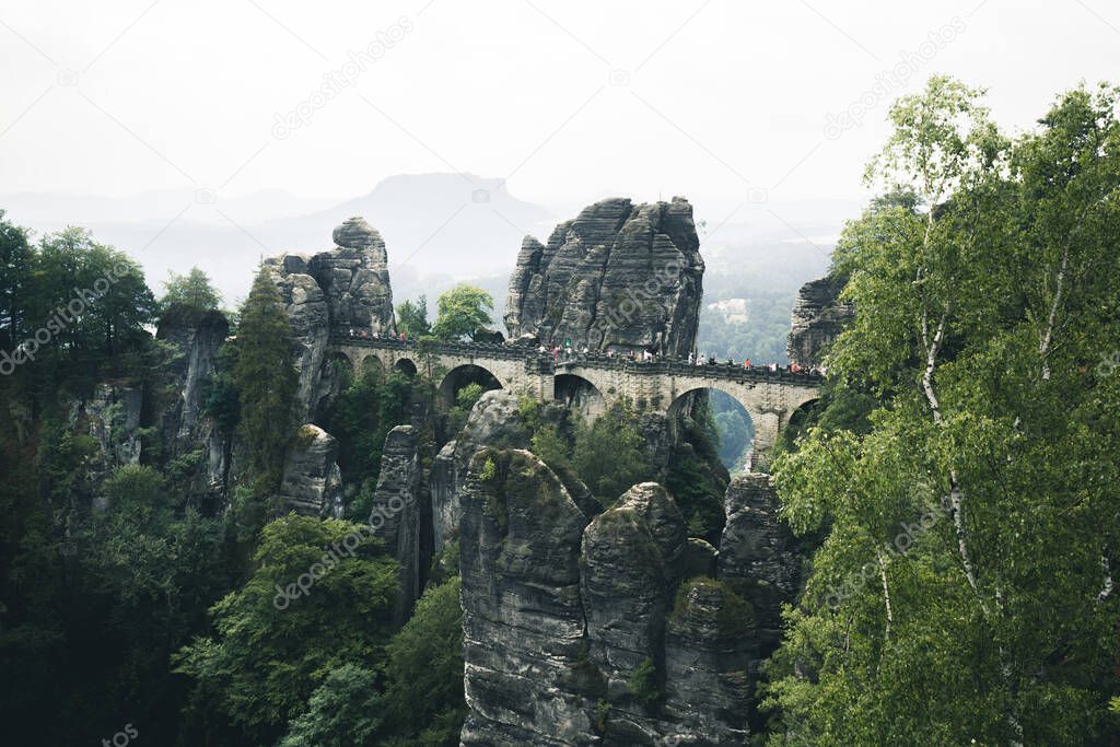 Beautiful panoramic view of famous Bastei Bridge with Elbe Sandstone mountains in Saxon Switzerland National Park on a moody day, Saxony, Germany