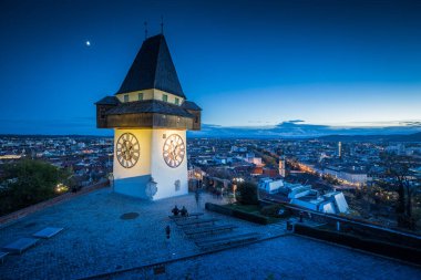 Ünlü Grazer Uhrturm 'un (saat kulesi) güzel alacakaranlık manzarası alacakaranlıkta, Graz, Styria bölgesinde aydınlandı, Avusturya