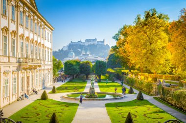 Avusturya, Salzburg 'da güneşli bir günde tarihi Hohensalzburg Kalesi' nin arka planında ünlü Mirabell Gardens 'ın klasik manzarası