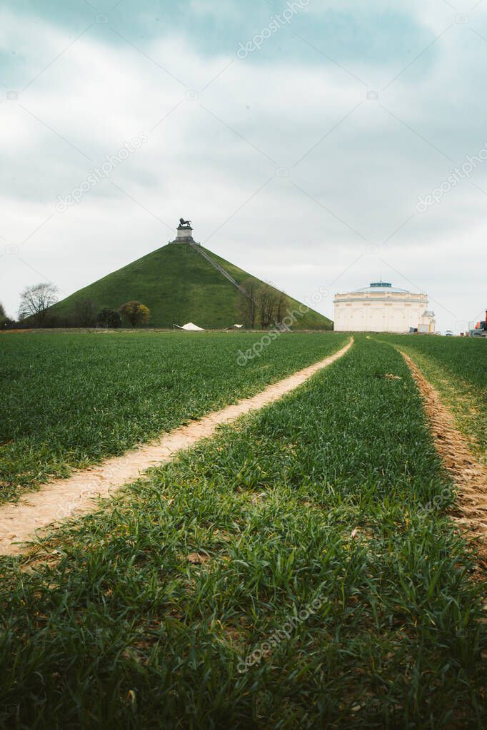 Panorama view of famous Lion's Mound (Butte du Lion) memorial site, a conical artificial hill located in the municipality of Braine-l'Alleud comemmorating the battle of Waterloo, on a moody day with dark clouds in summer, Belgium