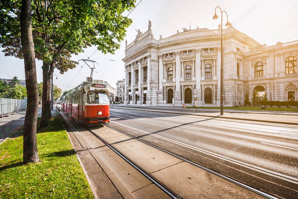 Famous Wiener Ringstrasse with historic Burgtheater (Imperial Court Theatre) and traditional red electric tram at sunrise with retro vintage Instagram style filter effect in Vienna, Austria