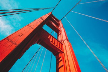 Yazın güneşli bir günde mavi gökyüzü ve bulutlarla ünlü Golden Gate Köprüsü 'nün alçak açılı güzel manzarası. Eski moda filtre efekti, San Francisco Körfez Bölgesi, Kaliforniya, ABD