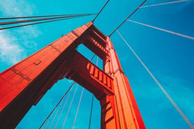 Beautiful low angle view of famous Golden Gate Bridge with blue sky and clouds on a sunny day in summer with retro vintage post crocessing filter effect, San Francisco Bay Area, California, USA clipart