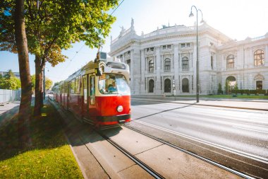 Avusturya 'nın başkenti Viyana' da antika Instagram tarzı filtre efektiyle gündoğumunda tarihi Burgtheater (İmparatorluk Mahkemesi Tiyatrosu) ve geleneksel kırmızı tramvayla ünlü Wiener Halkası