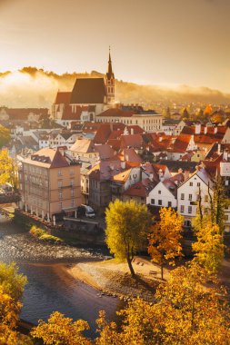 Tarihi Cesky Krumlov 'un 1992' den beri UNESCO 'nun Dünya Mirası Alanı olan ünlü Cesky Krumlov Şatosu' nun panoramik manzarası, Çek Cumhuriyeti 'nin sonbaharda sisli bir sonbaharda gün doğumunda güzel bir altın sabah ışığı altında