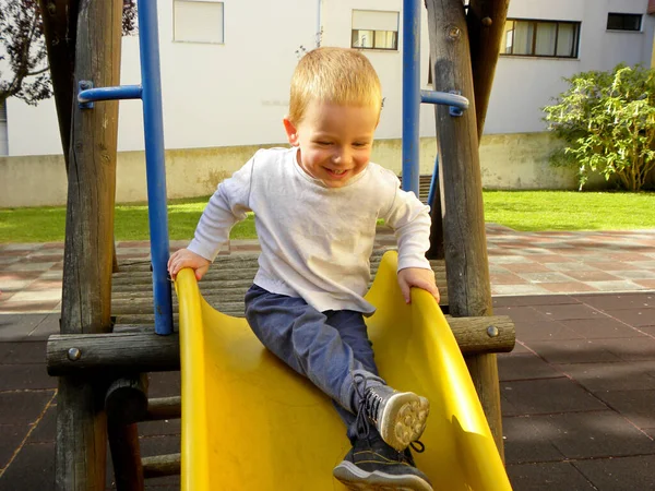 Charming Three Year Old Boy Riding Yellow Plastic Slide Park — Stock Photo, Image
