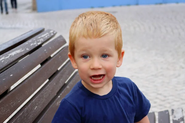 Çekici sarışın bir çocuğun portresi. Üç yaşında bir çocuk ağzı açık gülümsüyor. Mutlu çocuk.