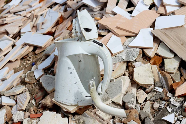 Broken electric kettle at a construction waste dump. A large dump of old and unusable household appliances.