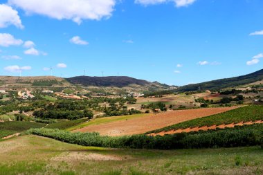 Portekiz 'in doğal manzarasının muhteşem panoramik manzarası. Mavi gökyüzü, yüksek tepeler, rüzgar türbinleri ve geleneksel seramik kiremitli çatı evleri