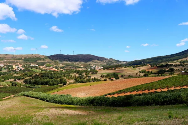 Portekiz 'in doğal manzarasının muhteşem panoramik manzarası. Mavi gökyüzü, yüksek tepeler, rüzgar türbinleri ve geleneksel seramik kiremitli çatı evleri