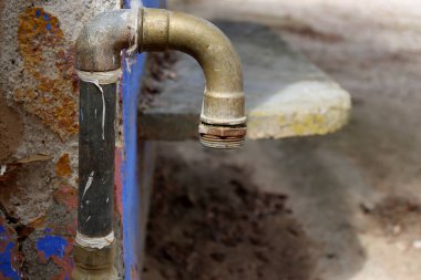 Bulanık gri arkaplanda eski bakır musluk.