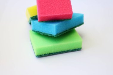 Beyaz arka planda bulaşık yıkamak için çok renkli süngerler.