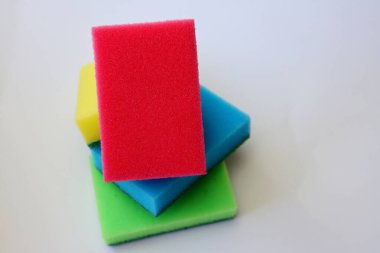 Beyaz arka planda bulaşık yıkamak için çok renkli süngerler.