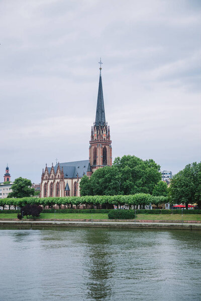 FRANKFURT, GERMANY - 28 JUNE 2018: beautiful Frankfurt Church of Three Kings near park and Main river