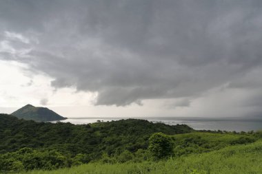 Volkan Adası-Binintiang Malaki ya da Büyük Bacaklı Krater-Taal Gölü 'nden Tagaytay Tepesi' ne kadar uzanan Volkan Yolu 'nun üzerindeki tehlikeli bulutlu gökyüzü manzarası. Talisay-Batangas Bölgesi-Luzon Adası-Filipinleri.
