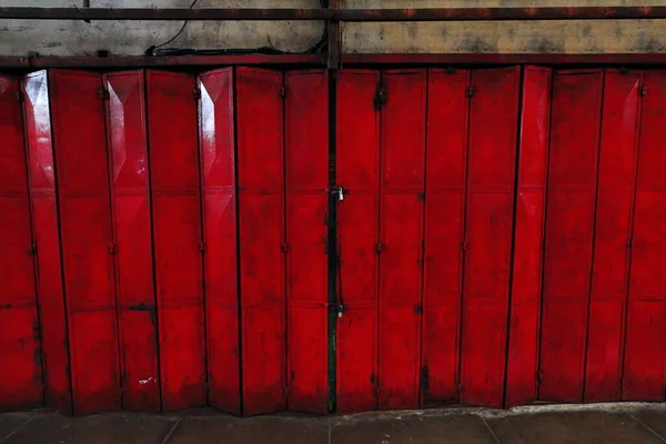 Orange-red painted padlock-closed iron hinged folding door of a stall selling local items facing a corridor of the Central Public Market. Bacolod city-Negros Occidental-Western Visayas-Philippines.