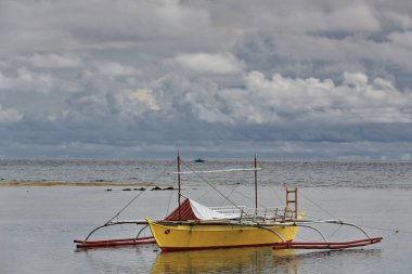 Punta Ballo sahilinde karaya oturmuş dalış ve şnorkelle yüzme merkezlerinin turistik kullanımı için Balangay ya da Bangka çift kanatlı teknesi. Sipalay-Zenciler Batı Visayas-Filipinler.