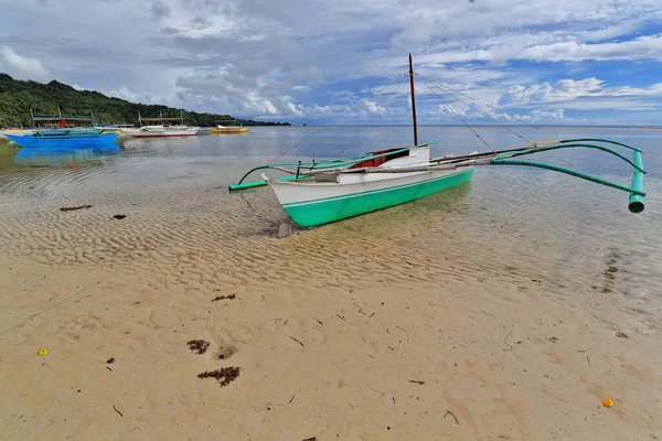 近くのダイビングスポットやプンタバロビーチの砂の上にあるシュノーケリングリゾートを観光に使用するためのBalangayまたはBangkaダブルトリガーボート シパライ ネグロス オクティデンタル ウェスタン ビサヤ フィリピン — ストック写真