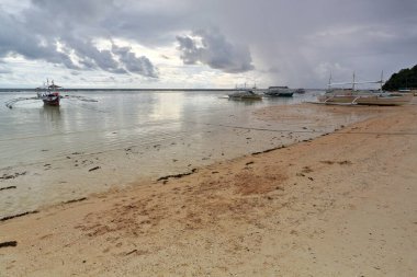 Punta Ballo sahilinde karaya oturmuş dalış ve şnorkelle yüzme merkezlerinin turistik kullanımı için dengeleyici ya da bangka çift kanatlı tekneler. Sipalay-Zenciler Batı Visayas-Filipinler