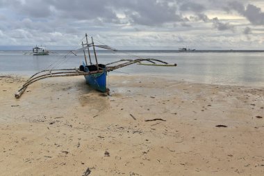 Punta Ballo sahilinde karaya oturmuş dalış ve şnorkelle yüzme merkezlerinin turistik kullanımı için dengeleyici ya da bangka çift kanatlı tekneler. Sipalay-Zenciler Batı Visayas-Filipinler