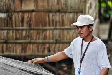 Sipalay, Filipinler-13 Ekim 2016: Balıkçı, Panaon nehir ağzındaki liman bölgesinde bir sonraki sefere hazırlanmak için ağları onarıyor. Zenciler Batı-Batı Visayaları.