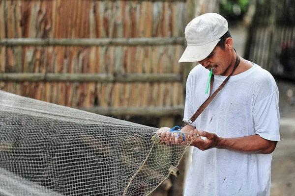 Sipalay, Filipinler-13 Ekim 2016: Balıkçı, Panaon nehir ağzındaki liman bölgesinde bir sonraki sefere hazırlanmak için ağları onarıyor. Zenciler Batı-Batı Visayaları.