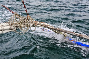 Filipinli bir bangka teknesinden yansıyan Outrigger ana gövdenin yan tarafındaki dengelenme için yan destek şamandırası görevi görüyor. Kuzey Körfezi-Zenciler Doğu-Merkez Visayas-Filipinler.