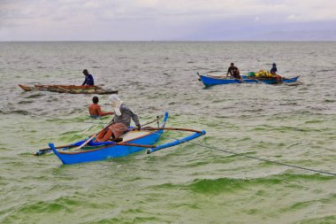 North Bays Bay, Filipinler-15 Ekim 2016: Eski Filipinli balıkçılar Manjuyod Beyaz Kum Barı 'nı ziyaret eden turistlere yiyecek satmaya çalışıyorlar:.