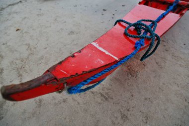 Şiddetli bir yağmurun ardından gün batımında sahilde mahsur kalan kırmızı balıkçı teknesi, yerel restoranlar için olağan görev balıkçılığını yapmak üzere denize açılmasını engelledi. El Nido-Palawan-Filipinler.