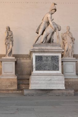 Floransa, İtalya-16 Mayıs 2022: Loggia della Signoria veya dei Lanzi altındaki heykeller 1376-82 yılları arasında Gotik tarzda inşa edilmiş ve Rönesans detayları Benci Dami ve Simone Talenti tarafından halka açık törenlere ev sahipliği yapmak üzere düzenlenmiştir..