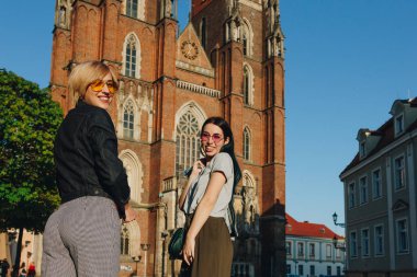 Wroclaw katedral önünde duran ve kameraya bakarak iki çekici gülümseyen kadın