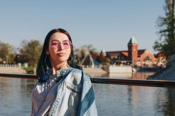 close-up portrait of young woman in stylish clothes on sunset in wroclaw, poland