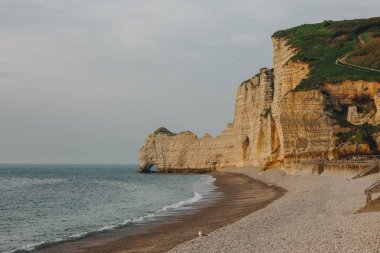 scenic shot of dramatic seashore on cloudy day at Etretat, France clipart