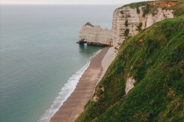 aerial view of scenic rocky cliff with green grass on foreground at Etretat, France clipart