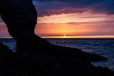 bulutlu gün batımı, Etretat, Fransa üzerinde kayalık uçurum sakin atış