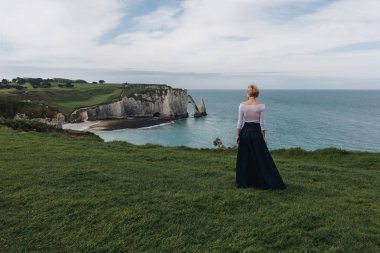 Arkadan Görünüş genç kadının poz görkemli cliff, Etretat, Normandy, Fransa