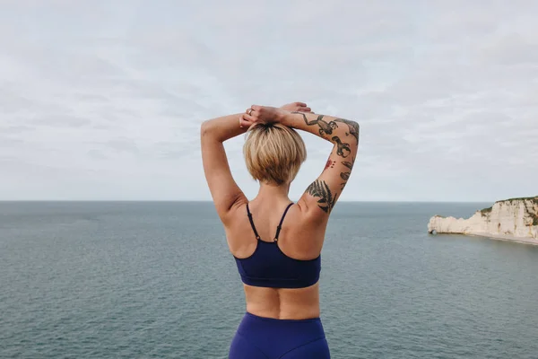 Bageste Udsigt Tatoveret Atletisk Pige Stilfuld Sportstøj Poserende Nær Havet - Stock-foto