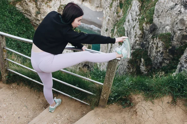 Beautiful Sportswoman Stylish Sportswear Stretching Legs Railings Etretat France — Free Stock Photo