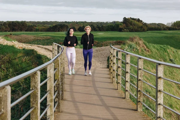 Mujeres Atléticas Corriendo Por Carretera Con Barandillas Etretat Normandía Francia — Foto de stock gratis