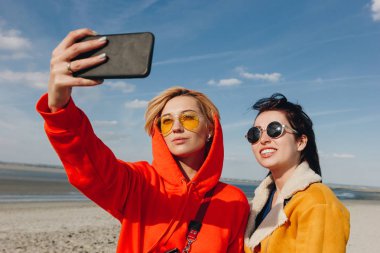 Selfie kumlu plaj alarak mutlu arkadaşlar, Saint michaels mount, Normandy, Fransa