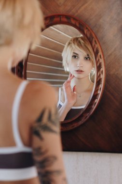 selective focus of beautiful young woman in underwear looking at mirror clipart