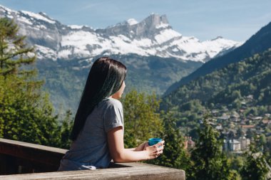 Balkonda duran ve doğal dağ, mont blanc, Alpler seyir sırasında Kupası tutan kız