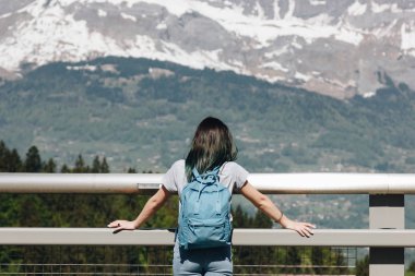 back view of girl with backpack looking at majestic scenic mountains, mont blanc, alps clipart
