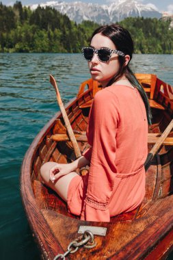 güzel genç kadın güneş gözlüğü oturan tekne sakin dağ Gölü, bled, Slovenya