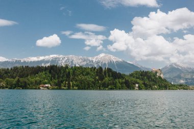 güzel karla kaplı dağ zirveleri, yeşil bitki örtüsü ve sakin göl, bled, Slovenya