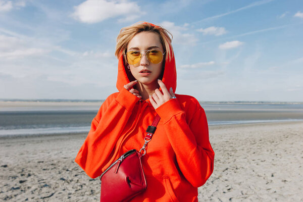 красивая девушка в красном капюшоне, стоящая на пляже, saint michaels mount, Франция
