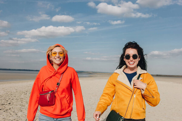 Счастливые девушки, гуляющие по песчаному пляжу, Сен-Мишель-Мунт, Нор, Франция
