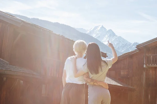 Vista Trasera Las Mujeres Jóvenes Abrazando Mirando Las Majestuosas Montañas — Foto de Stock