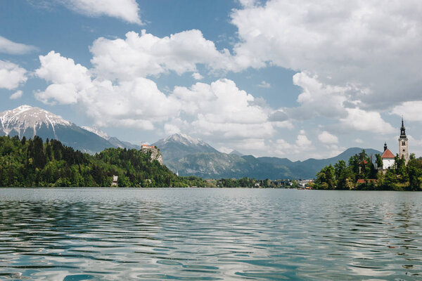 beautiful landscape with calm mountain lake, peaks and buildings, bled, slovenia